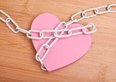 Un corazón rosa con unas cadenas.