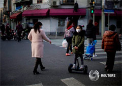 Una niña con una máscara monta un scooter en una calle del centro de Shanghái, China, el 23 de febrero de 2020.