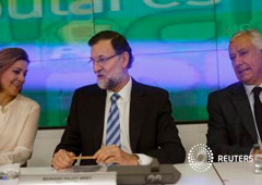 Rajoy (C) se sienta junto a la secretaria general del PP, María Dolores de Cospedal (I) y el vicesecretario general, Javier Arenas, antes del inicio de la Junta Directiva Nacional del partido en Madrid el 7 de abril de 2015
