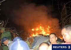Imagen del 4 de noviembre de los rescatistas con los restos del avión incendiado detrás, cerca de Guasimal, en el centro de Cuba.