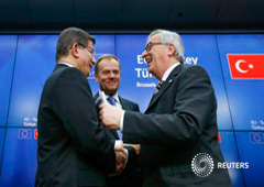 El primer ministro turco Ahmet Davutoglu (I), el presidente del Consejo Europeo Donald Tusk (C) y el presidente de la Comisión Europea Jean Claude Juncker (D) se saludan después de una rueda de prensa tras la cumbre UE-Turquía en Bruselas el 8 de marzo de