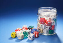 A vueltas con la regulación y tributación del juego Un bote de cristal con dados de colores.