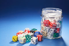 A vueltas con la regulación y tributación del juego Un bote de cristal con dados de colores.