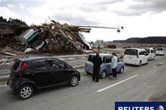 Los daños del seísmo en Japón sumarían hasta 216.000 millones Unas personas esperando para llenar el depósito en una gasolinera en Motoyoshi, un pueblo destruido por el terremoto y el posterior tsunami.