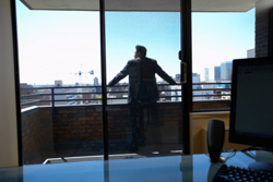 Un ejecutivo mirando por la ventana de su despacho.