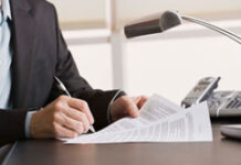 De cara a la próxima Campaña de Renta 2014 en País Vasco Una persona sentada en una mesa con unos papeles en las manos.