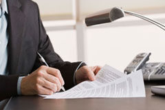 De cara a la próxima Campaña de Renta 2014 en País Vasco Una persona sentada en una mesa con unos papeles en las manos.