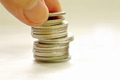 ¿Se ha visto afectada la Ley de Acceso a la Abogacía por la crisis que sufrimos? Unos dedos sobre un montoncito de monedas