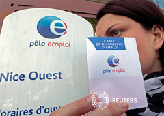 Una mujer sostiene una cartilla de solicitante de empleo ante una Agencia Nacional de Empleo en Niza