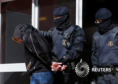 La policía escolta a un sospechoso detenido en un bloque de pisos durante la operación, en Sabadell, el 8 de abril de 2015