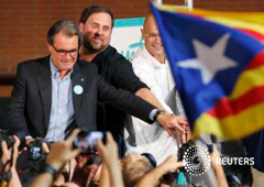 De izquierda a derecha, el presidente de la Generalitat, Artur Mas, Oriol Junqueras, y Raul Romeva, delante de una bandera catalana independentista durante la presentación de los candidatos de la coalición soberanista Junts pel Si en el centro de Barcelon