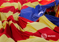 Personas llevando una bandera independentista catalana gigante durante la Diada, en Barcelona, el 11 de septiembre de 2017