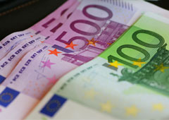 Un empleado bancario muestra billetes de 100 euros en una sucursal en Madrid el 13 de enero de 2011