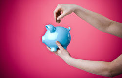 Cuestiones Prejudiciales Tributarias Persona insertando una moneda en una hucha