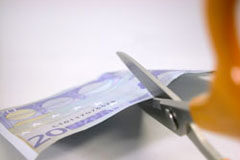 La cuota de autónomos y la tarifa plana Dinero cortado por una tijera.