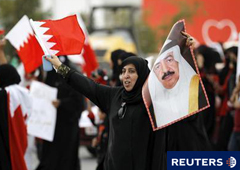 Una mujer bahrení sostiene un poster del primer ministro el príncipe Jalifa bin Isa al-Jalifa mientras grita eslóganes antigubernamentales durante una protesta en Riffa, una zona suní al sur de la capital de Bahréin de Manama, el 16 de febrero de 2011