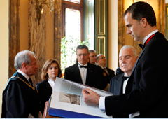 Don Felipe observa el libro conmemorativo en presencia de Carlos Dívar