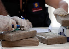 Policía abriendo paquetes con droga