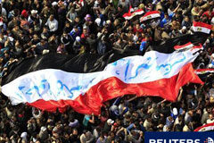 El consejo militar egipcio nombra primer ministro a Ganzuri manifestantes egipcios marcha con una gran bandera durante una protesta en la Plaza de Tahrir, en El Cairo