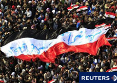 manifestantes egipcios marcha con una gran bandera durante una protesta en la Plaza de Tahrir, en El Cairo