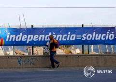 Un hombre pasa junto a una pancarta electoral del partido Solidaritat Catalana per la Independència (SI) en Cabrera de Mar, cerca de Barcelona, el 21 de mayo de 2015