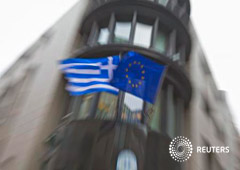 Una bandera griega y una de la Unión Europea en la fachada de la embajada griega en Bruselas el 19 de febrero de 2015
