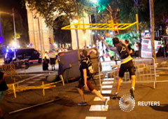 Imagen de los manifestandtes lanzando vallas contra la policía tras la manifestación celebrada el 1 de octubre en Barcelona, España