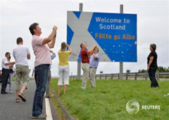 Unos turistas suizos hacen fotos de un cartel en la carretera que marca la separación entre Inglaterra y Escocia cerca de la localidad de Berwick, en agosto del año pasado