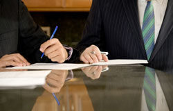 El recurso de casación contra auto de sobreseimiento Dos hombres de traje sentados escribiendo en una reunión.