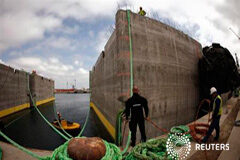 España también reducirá las tasas portuarias para mantener el comercio Trabajadores ante piezas de cemento en la bahía de Algeciras, el 15 de abril de 2013