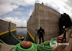 Trabajadores ante piezas de cemento en la bahía de Algeciras, el 15 de abril de 2013