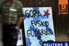 Detenidas siete personas del aparato internacional de ETA En la imagen, un hombre pasa junto a un cartel de apoyo a los "soldados" de ETA el 27 de septiembre de 2010 en Guernica.