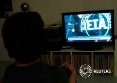 A woman watches a news program announcing the dissolution of armed Basque separatists ETA due for the first week of May, according to local television station ETB, in Guernica, April 18, 2018