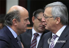 El primer ministro luxemburgués y presidente del Eurogrupo, Jean-Claude Juncker (D), habla con el ministro español de Economía, Luis de Guindos, el 20 de noviembre de 2012 en Bruselas