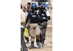 Un experto en sustancias químicas de la ONU , con máscara antigás, lleva muestras recolectadas de uno de los lugares donde se produjo el supuesto ataque con gas en el barrio de Ain Tarma en Damasco, el 28 de agosto de 2013