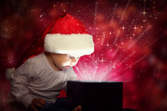 Todo el equipo de Thomson Reuters queremos desearte Feliz Navidad y Próspero Año Nuevo Un niño mirando el contenido de una caja