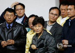 El presidente sucoreano Geun-hye (C) escucha a una familiar de un pasajero desaparecido en el ferry 