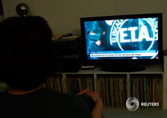 Una mujer ve un programa de la cadena vasca ETB que anuncia el fin de ETA, en Guernica