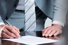 La extinción del contrato por impago de salarios sí permite el acceso a la jubilación anticipada involuntaria Una persona firmando un documento