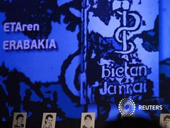 Imágenes de presos de ETA fotografiadas ante el logo de la organización, en Guernica