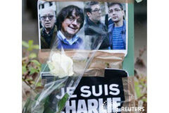 Francia llora mientras continúa la búsqueda de dos sospechosos Las fotos de los caricaturistas asesinadoss Georges Wolinski, Cabu, Tignous y Charb y un cartel con la leyenda "Yo soy Charlie" frente a la oficina de Charlie Hebdo en París, el 8 de enero de 2015