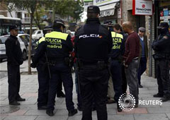 Agentes de policía municipal acompañana a los funcionarios judiciales a un desahucio de un inmigrante de la República Dominicana que fue finalmente suspendido, en Madrid