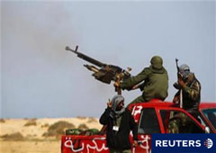 Combatientes rebeldes disparan contra las tropas de Gadafi cerca de Bin Jawad, en el este de Libia, el 29 de marzo de 2011.