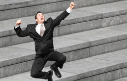 El concurso de Legal Today ya tiene sus primeros ganadores Un hombre de traje dando un salto de alegría en unas escaleras.