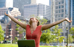 Y los ganadores son… Una chica levantando los brazos en señal de victoria mientras sostiene su portátil entre las piernas.