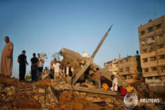 Israel bombardea Gaza por el aumento de ataques con proyectiles Un grupo de palestinos junto a los escombros de una vivienda que según la policía fue destruida en un ataque aéreo israelí en Gaza el 9 de julio de 2014