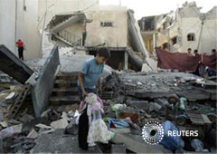 Un niño palestino con una muñeca en las manos entre los escombros de una casa destruida por un ataque aéreo israelí en Rafah el 20 de noviembre de 2012