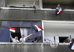varias mujeres gritan contra Mursi desde las ventanas de sus casas en Alejandría el 1 de julio de 2013