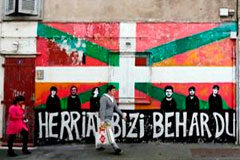 ETA se plantea su disolución definitiva para antes del verano Personas caminando ante un grafiti con una bandera vasca en Bayona, Francia.