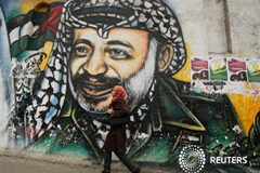 Los expertos forenses revelarán hoy sus hallazgos sobre el caso Arafat Un estudiante palestino pasea junto a un mural que muestra a Arafat, en Gaza, el 7 de noviembre de 2013